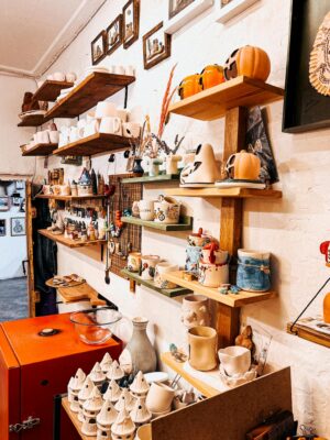 Vibrant pottery and ceramics displayed in a cozy art studio corner.